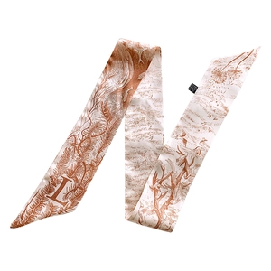 Macro detail of silk scarf featuring natural feather prints and a decorative letter L