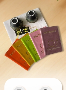Close-up of five colorful PU leather passport covers with gold foil heart plane logo