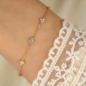 Elegant gold four-leaf clover bracelet with white diamonds on a minimalist chain
