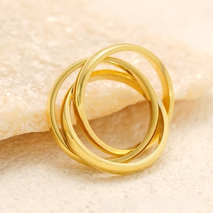 Macro shot of 18k gold triple interlinked rolling rings on a natural stone base