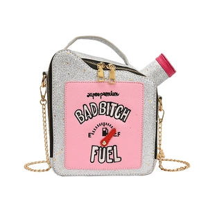 Macro shot of a silver sequined gas can bag with pink embroidery and golden chain