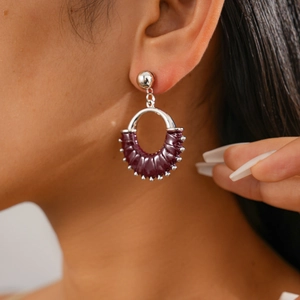 Close-up of retro geometric purple leather earrings with polished silver studs on model