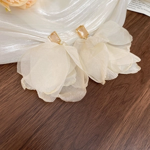 Close-up of champagne zircon and cream organza flower petals on delicate earrings