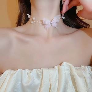 Detailed view of layered lace butterfly choker with imitation pearls on model