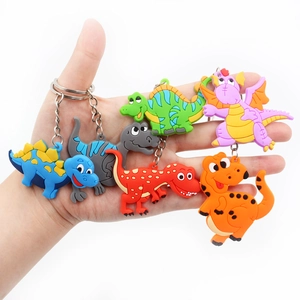 Close-up of colorful PVC cartoon dinosaur keychains held in hand with metal rings