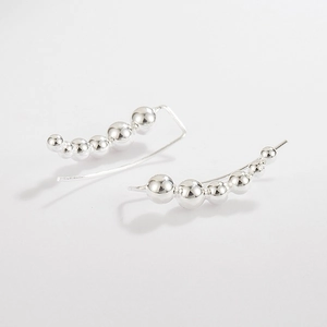 Detailed view of polished silver bead curve earrings with high metallic luster