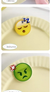 Detail view of sleeping and angry emoji hair clips made of glossy acrylic material