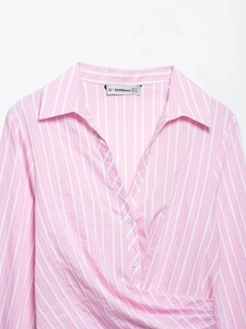 Detailed view of pink and white striped V-neck collar with brand label and fine stitching