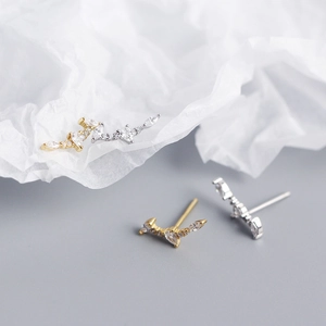 Detail view of silver and gold long curved vine earrings with marquise cubic zirconia