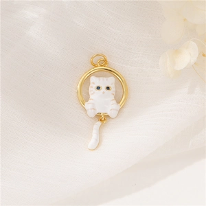 Detailed shot of white enamel cat pendant with blue crystal eyes and golden ring