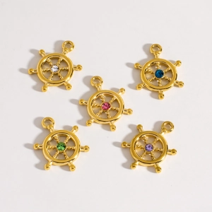 Detailed view of five golden ship wheel pendants with colorful inlaid gemstones on white