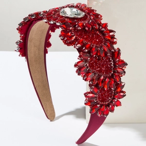 Détail d'un serre-tête baroque rouge avec fleurs en cristal 3D et gros strass