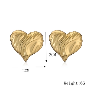 Macro detail of gold heart earrings showing dimensions 2cm x 2cm and textured metal finish