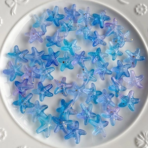 Detail of blue purple gradient starfish acrylic beads with gold glitter on white plate