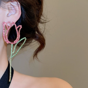 Detailed close-up of a pink tulip flower earring with green stem and sparkling crystals