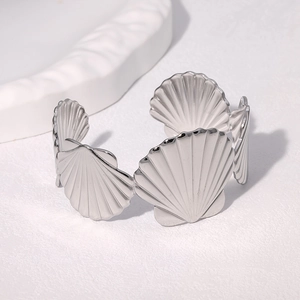Detailed view of silver stainless steel shell-shaped open bangle with radial textures