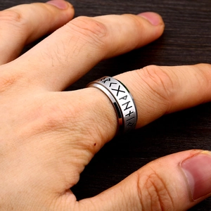 Detail of Viking rune engraved rotating stainless steel ring worn on a person hand