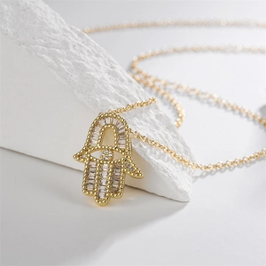 Détail du pendentif main de Fatma doré avec zircon rectangle sur pierre blanche