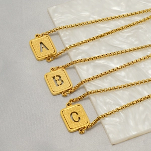 Detail of frosted gold square alphabet pendants A, B, C on O-chain stainless steel necklaces