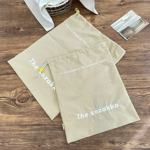 Close-up of two khaki drawstring storage bags with white cord and yellow toggle locks