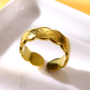 Macro detail of gold-plated stainless steel ring with elegant diamond-grid pattern texture
