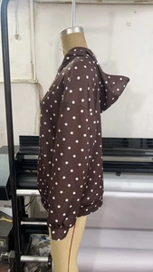 Détail d'un sweat à capuche marron à pois avec manches longues sur un mannequin