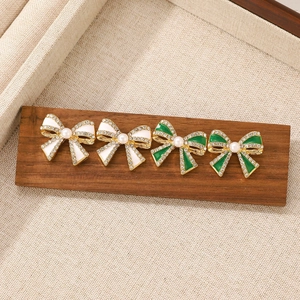 Elegant gold bow earrings with crystal diamonds and pearls in white and green colors