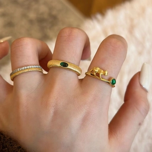 French vintage brushed gold cat ring with emerald green gemstone on a woman's finger