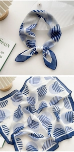 Detailed macro view showing the blue geometric patterns and fine texture of the linen scarf