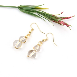 Detail of handmade gold wire wrapped earrings with clear crystal beads and French hooks