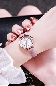 Close-up of rose gold watch with white Roman numeral dial and pink leather strap