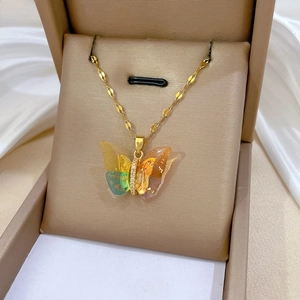 Macro shot of colorful butterfly pendant with gold foil and crystals on a sequin chain
