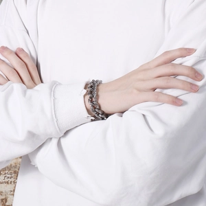 Close-up of vintage silver curb chain bracelet with skull relief textures on model