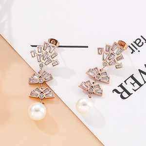Detail of rose gold tassel earrings featuring pavé cubic zirconia and white pearls