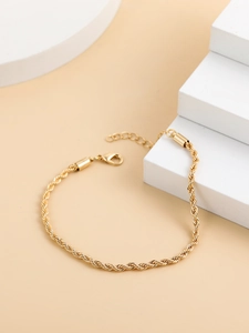 Detail view of gold-plated twisted rope chain bracelet with lobster clasp and extension