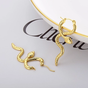 Chic gold stainless steel snake earrings with textured scales in a luxury display
