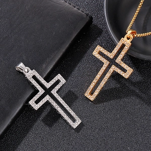 Macro detail of silver and gold plated cross pendants with rhinestones on dark background