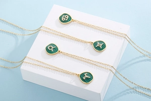 Detailed view of gold constellation pendants with green malachite and white crystals