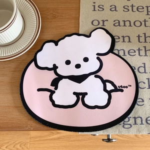 Cute pink oval mouse pad featuring a white puppy illustration on a wooden desk setup