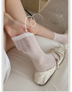 Close-up of breathable white vertical striped socks with sheer silk texture and bow shoes