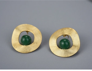 Detailed close-up of S925 silver round earrings with green stone and golden matte texture