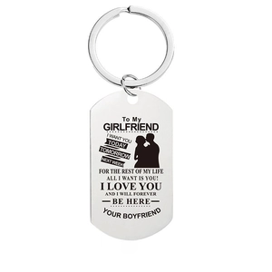 Macro detail of engraved stainless steel dog tag keychain for girlfriend with romantic text