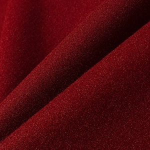 Macro shot of burgundy faux fur fabric with shimmering texture and refined grainy finish