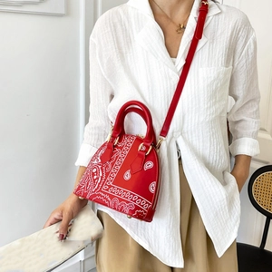 Detail of red bandana print shell bag with premium leather texture and crossbody strap