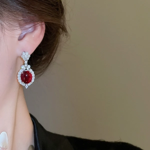 Close-up of elegant red oval flower stud earrings with diamonds on model's ear