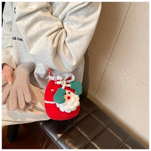 Detailed knit texture of a handmade Santa Claus crochet drawstring pouch in festive red