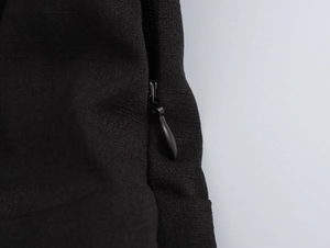 Detail of the high-quality invisible zipper and pleated black fabric on the dress