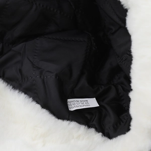 Close-up of winter lei feng hat inner quilted lining and 100% polyester material label