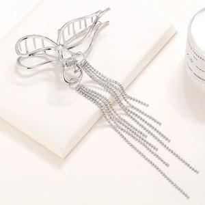 Silver metal butterfly hair claw clip with long sparkling rhinestone tassels on display