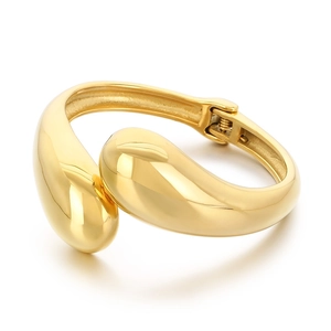 Polished gold-tone irregular teardrop bangle in stainless steel with hinge closure